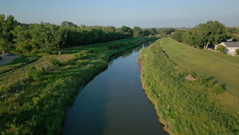 Aerial-of-blue-water-stream-snaking-its-way-through-a-home-community