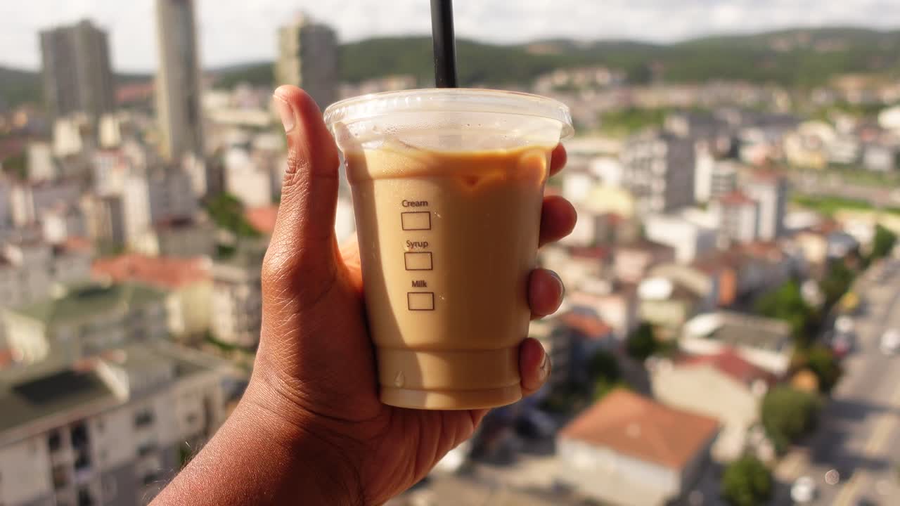 Iced Coffee in Hand with City View