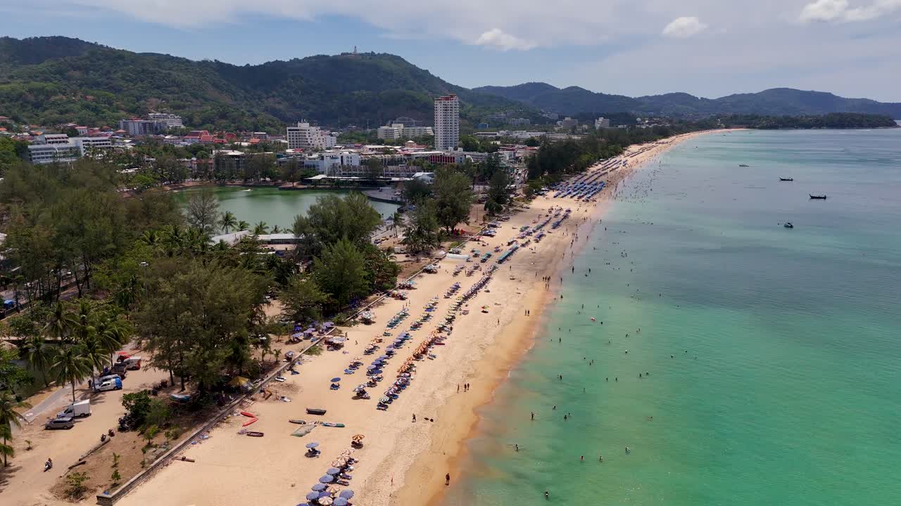 Droneoptagelser fanger den pulserende strand i Phuket, Thailand, og viser sandstrande, turkisblåt vand og frodigt grønt under klart dagslys