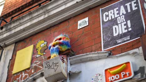 street art in brick lane in london, fluffy doll and inspirational sign to encourage creators to create, motivational message on the wall and graffiti, in slow-motion