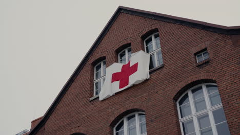 red cross flag on a brick building