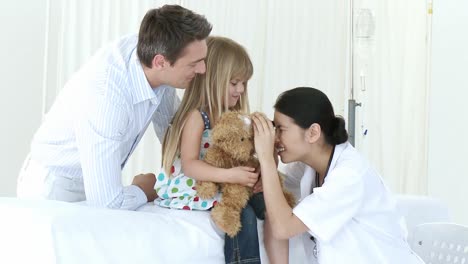 un médico asiático examinando a una niña en el hospital