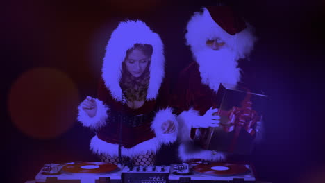 santa claus and woman in xmas costume djing for christmas time disco shoot