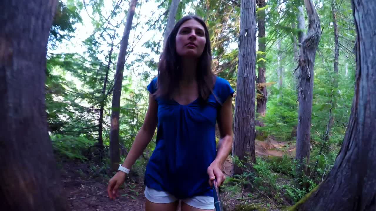 Mujer mirando alrededor mientras camina en el bosque 4k