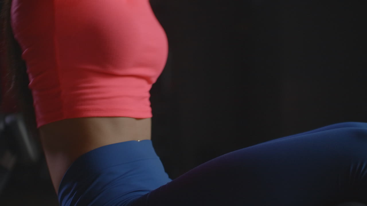 la joven en forma está haciendo ejercicios de músculos abdominales oblicuos en el gimnasio. está controlando su respiración y técnica. está cambiando de lado cada vez. este es un entrenamiento productivo por la mañana en el gimnasio.