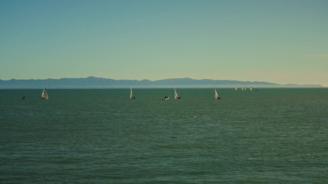 Boat cruising at Santa Barbra pier with oil rigs in the Pacific Ocean of the coast of California in the distance, Santa Barbara, California, United States of America - July 20 2023