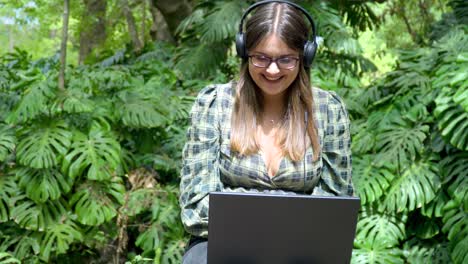 The-woman-student-is-very-happy-about-her-freelance-work,-acting-confident-and-smiling-while-using-a-laptop