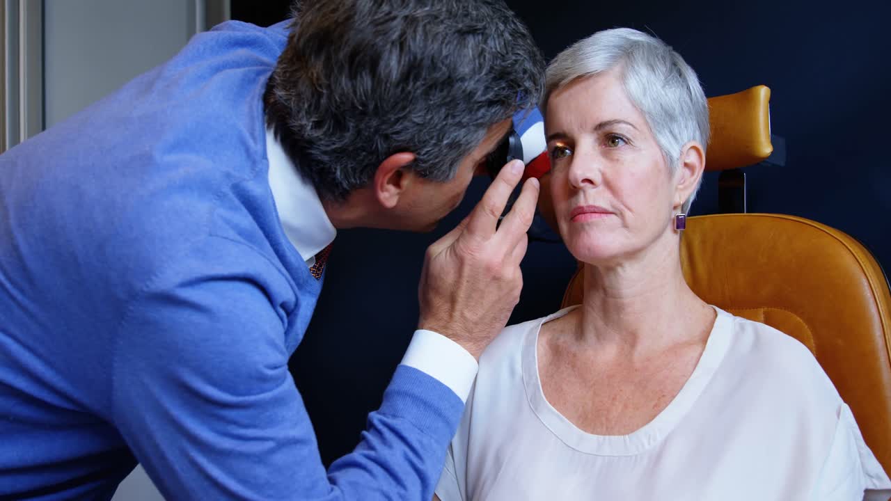 optometrista examinando los ojos del paciente con un oftalmoscopio 4k