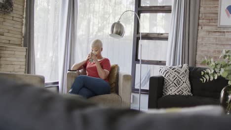 happy biracial woman drinking coffee at home in slow motion