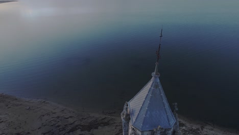 Aerial-drone-shot-of-old-castle-tower-with-sunset-sky