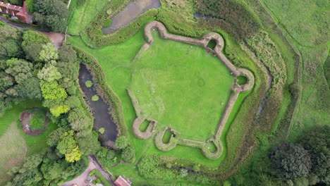 Aerial-video-footage-of-the-remains-of-Bolingbroke-Castle-a-13th-century-hexagonal-castle,-birthplace-of-the-future-King-Henry-IV,-with-adjacent-earthwork