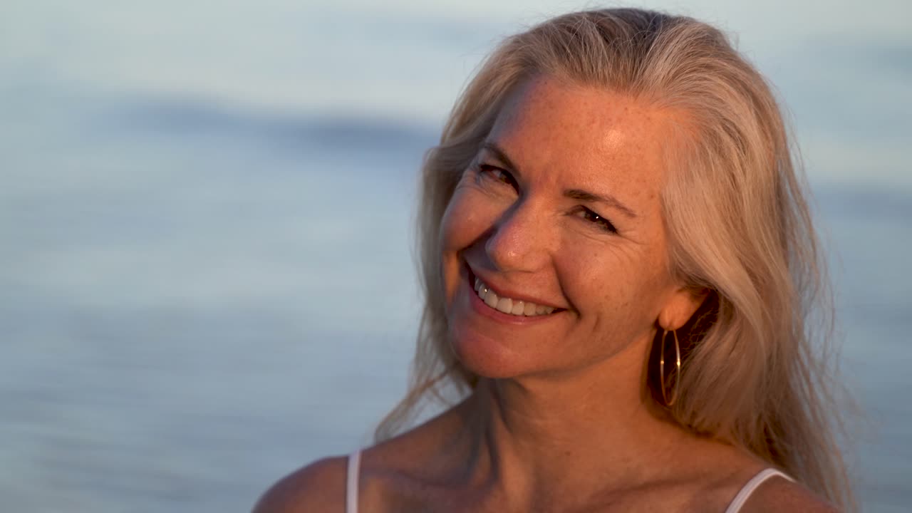 светловолосая зрелая женщина кивает головой в знак согласия, улыбаясь и глядя в камеру