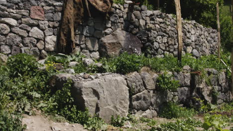 stone wall and well with wooden water troughs in garden rockery