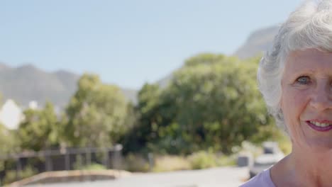 Portrait-of-happy-senior-caucasian-woman-in-sunny-garden,-unaltered,-in-slow-motion,-copy-space