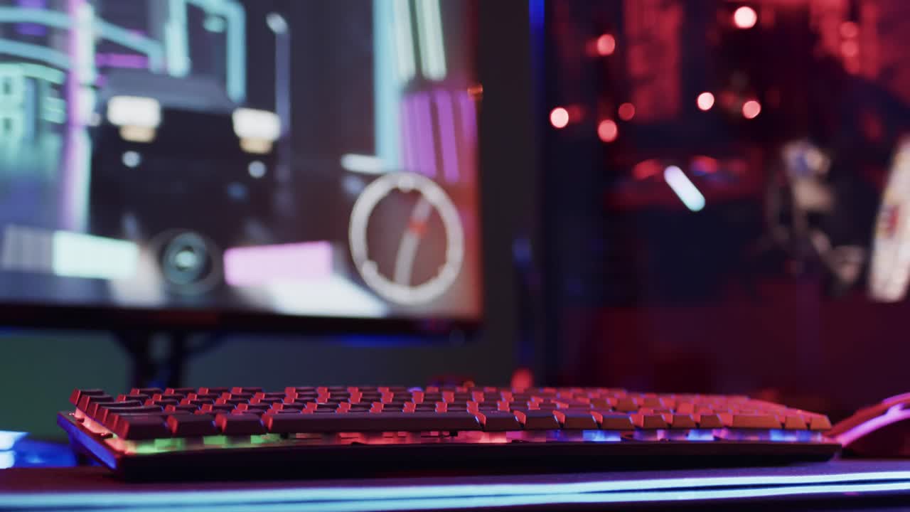 Video of computer and gaming equipment on desk with copy space on neon background