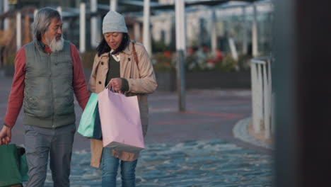 pareja de ancianos, de compras y tomados de la mano