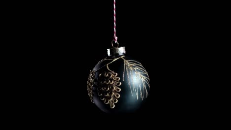 4k. juguete de pelota de año nuevo negro gira brillando y iluminando la luz. navidad y decoración de año nuevo aislada en fondo negro.