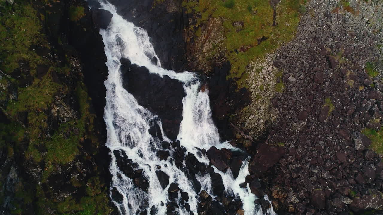 Aerial Rising Crane and Panning Shot of Impressive Låtefossen Waterfall Flowing Among Rocks and Boulders