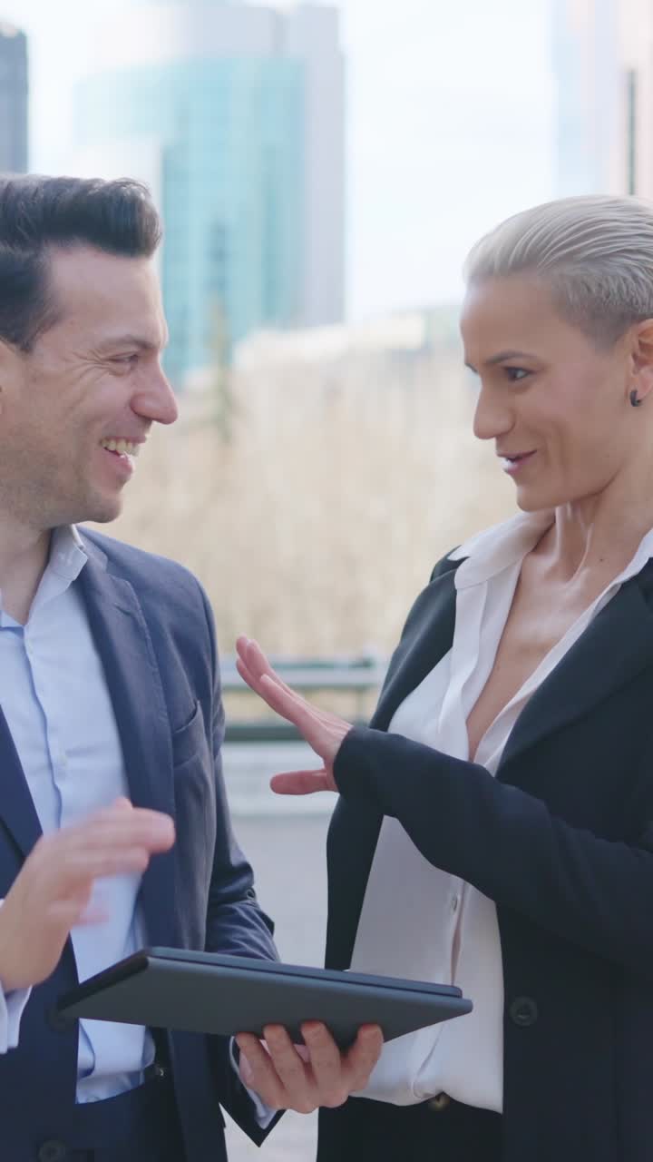 Duo professionale che collabora con un tablet in ambiente urbano