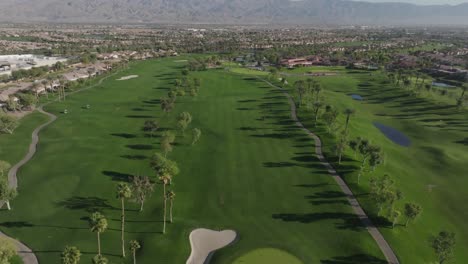 Campo-De-Golf-Heritage-Palms-En-Indio,-California,-Con-Video-De-Drones-Saliendo-De-Una-Vista-Verde-Cercana