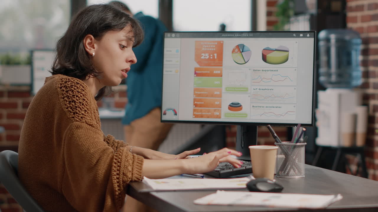 Woman working with data analytics on computer in office