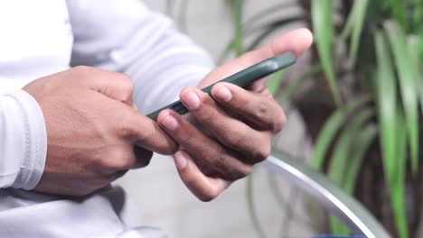 person using a dark green smartphone