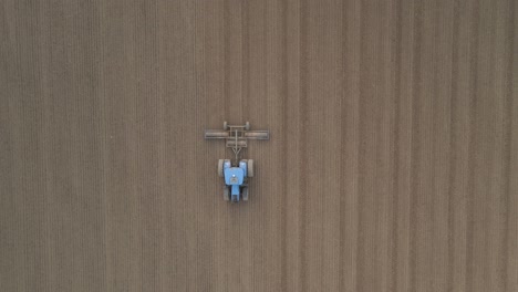 Tractor-Working-In-Field-In-Ireland---aerial-top-down