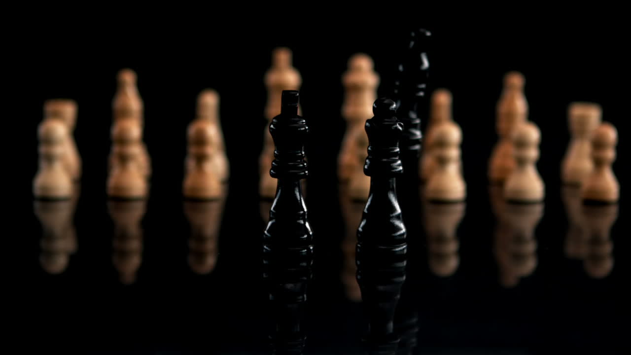 Black chess piece falling beside other pieces