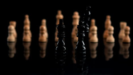 black chess piece falling beside other pieces