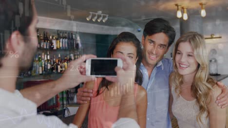 animación de procesamiento de datos sobre un camarero caucásico tomando una foto de un grupo de amigos en un bar.