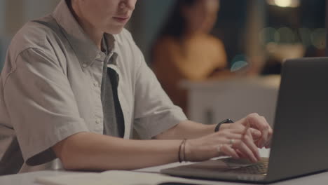 businesswoman typing on laptop at office desk during night