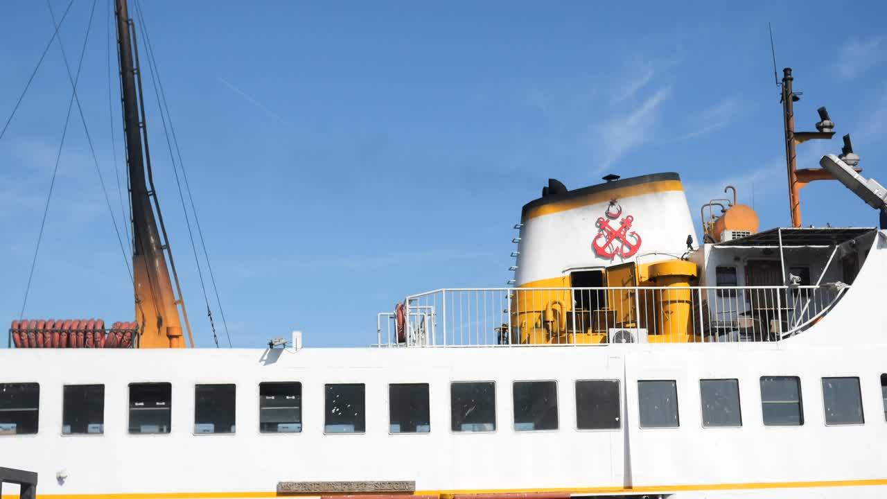 에 빨간 커가 그려진 색과 노란색의 페리 보트의 앞부분의 클로즈업