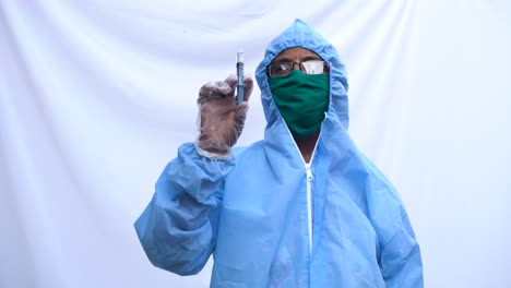 doctor in ppe kit blue protective suit, surgical mask latex gloves