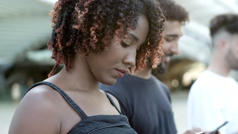 una joven alegre enviando mensajes de texto con su teléfono inteligente