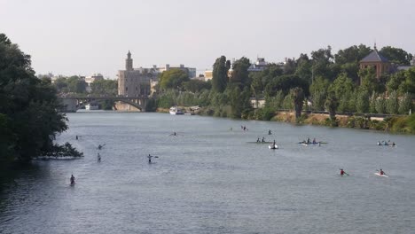 Menschen,-Die-Den-Fluss-Guadalquivir-In-Sevilla-Befahren,-Im-Hintergrund-Der-Torre-Del-Oro