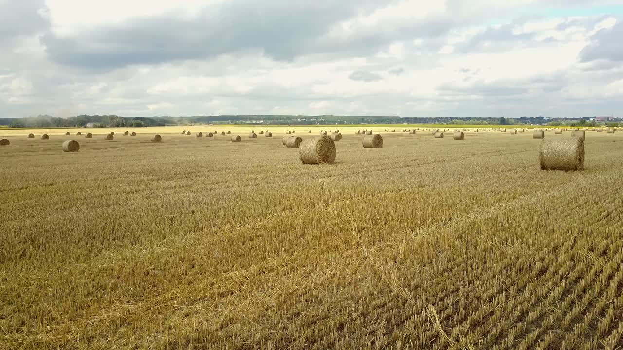 Round Bales Of Straw. Straw bales on farmland with blue cloudy sky
