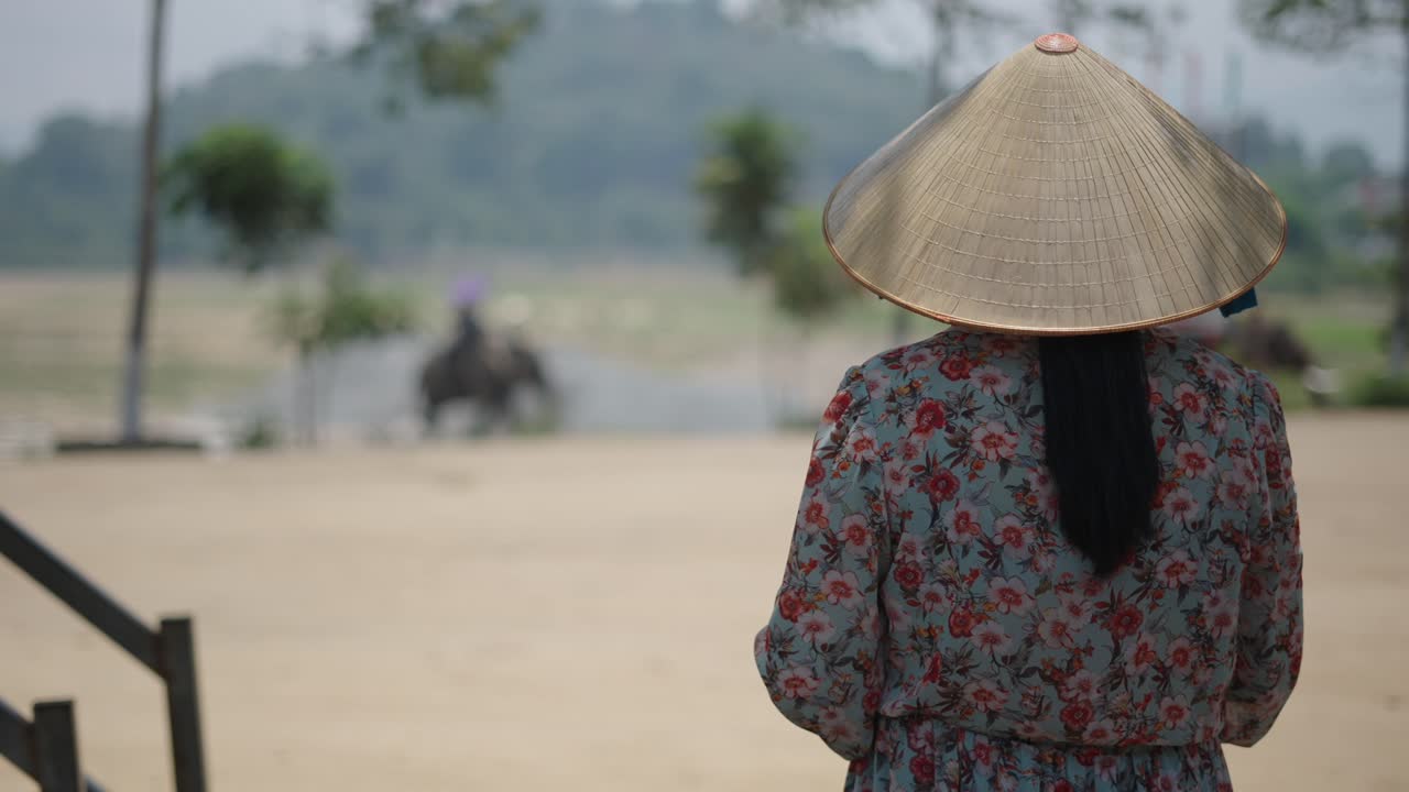Woman Watching Tourists Riding Elephants