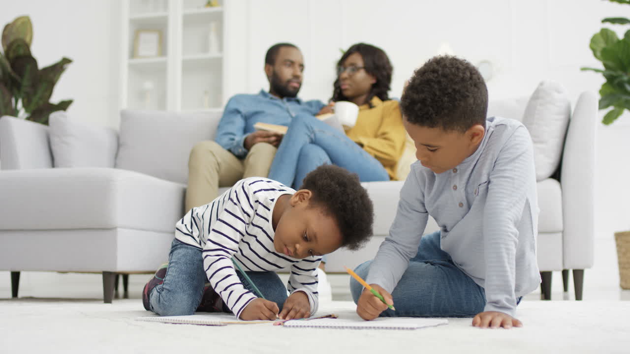 Happy Kids Sitting On Floor And Coloring Picture With Pencils