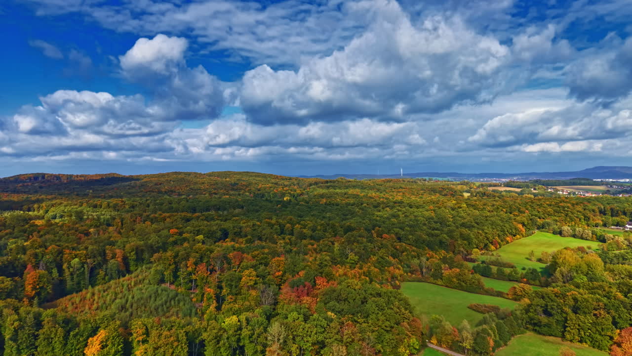Vibrant autumn landscape showcasing rolling hills, colorful foliage, and a breathtaking sky