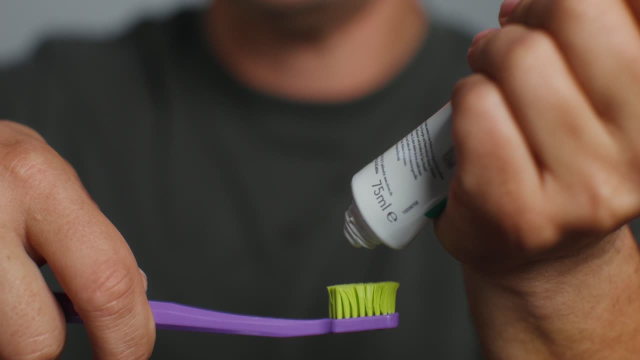 Man applying toothpaste to toothbrush