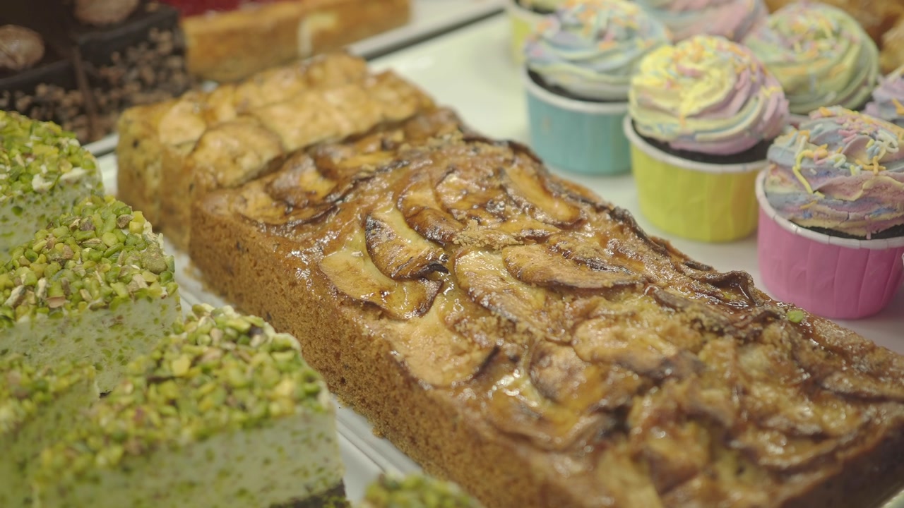 Variety of Delicious Cakes and Colorful Cupcakes in a Bakery Display