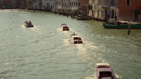 taxi boat on the water of canal grande in venice, italy, is cruising under a bridge in the morning sunlight