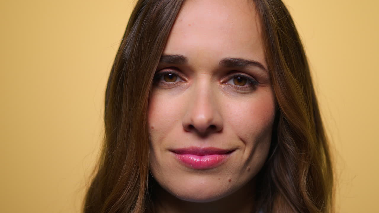mujer joven agitando la cabeza sí a la cámara. chica sonriendo sobre fondo amarillo