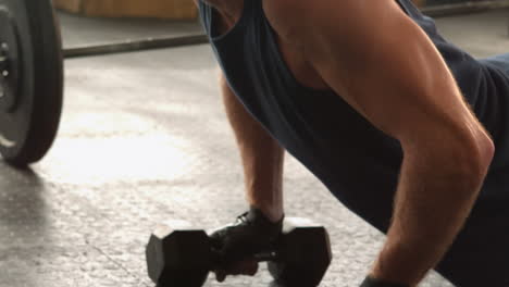 hombre en forma haciendo flexiones en el estudio de crossfit