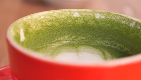 empty matcha latte in a red cup