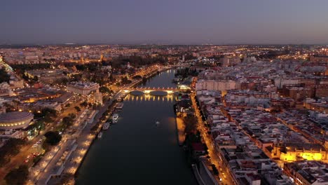 aerial view of san telmo bridge at night with seville cityscape panoramic view