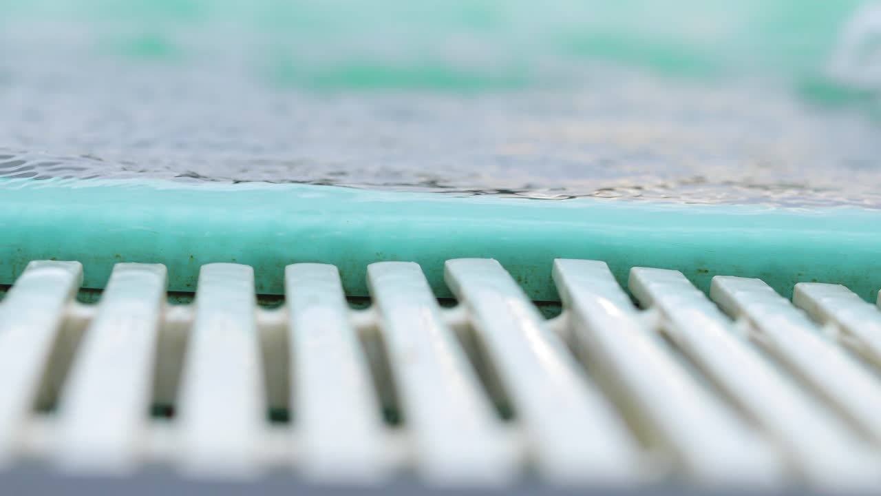cerca de un borde de piscina con desagüe blanco