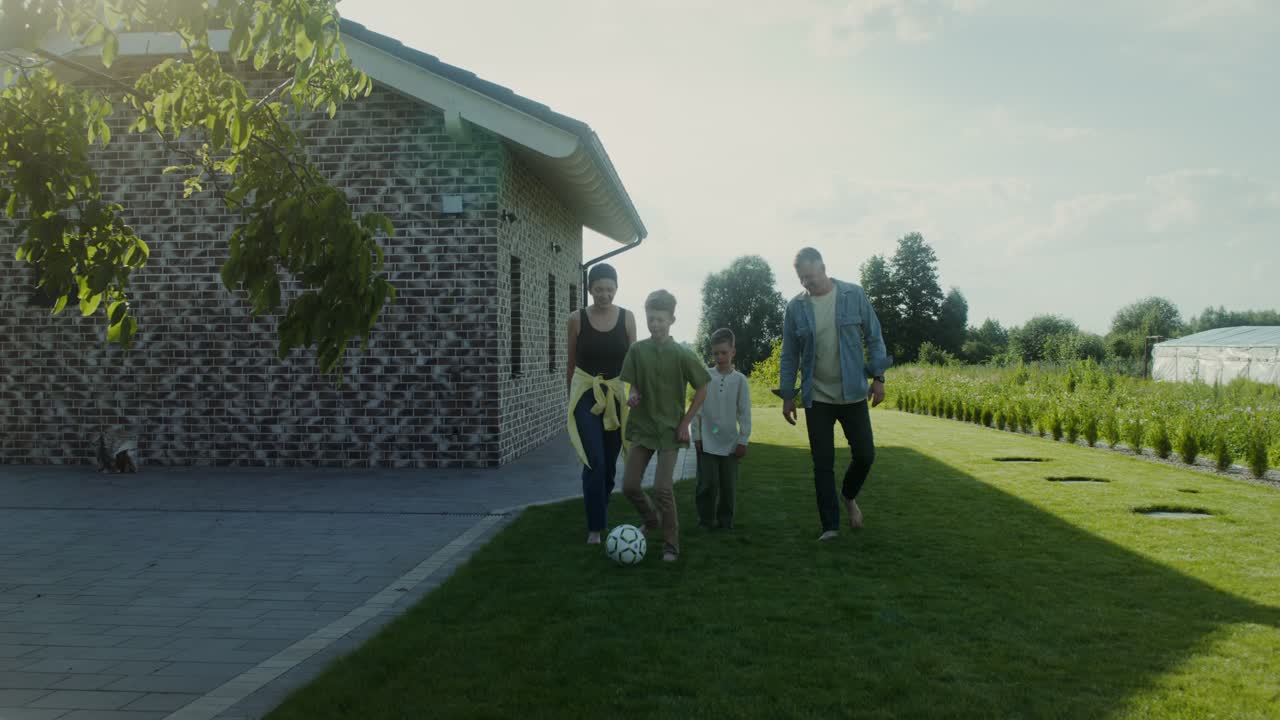 정원에서 축구 를 하는 가족