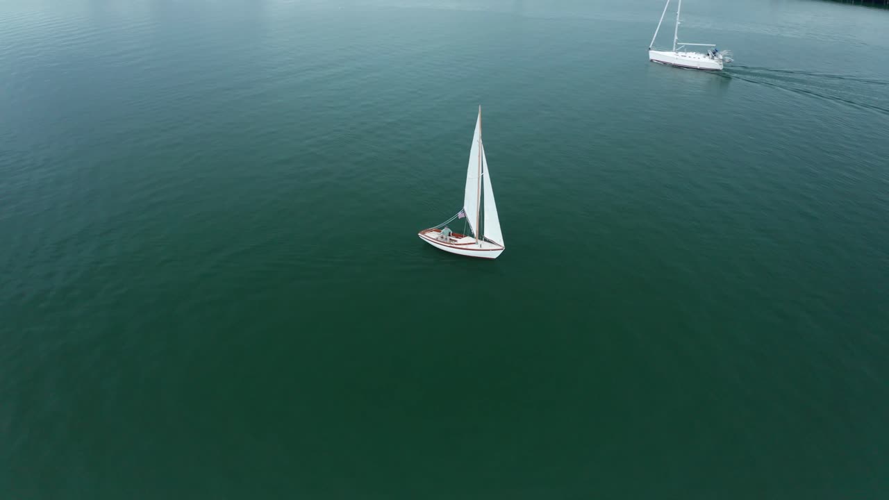 dos barcos pasan por el carril del puerto deportivo de la bahía en un día soleado y nublado