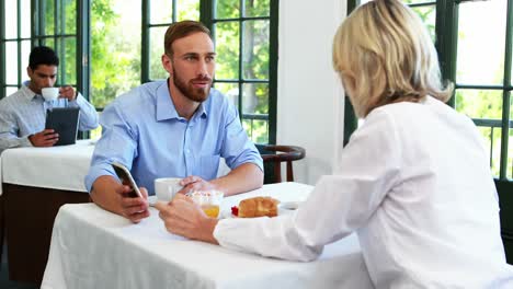 male and female executives discussing over mobile phone 4k